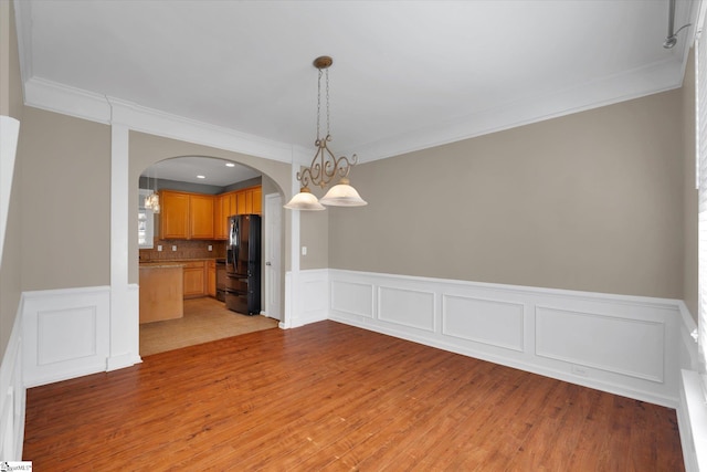 spare room with crown molding and light hardwood / wood-style flooring