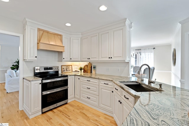 kitchen featuring white cabinetry, double oven range, sink, and custom range hood