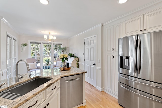 kitchen featuring sink, ornamental molding, light stone countertops, and appliances with stainless steel finishes