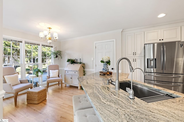 kitchen featuring light stone countertops, white cabinets, and stainless steel refrigerator with ice dispenser