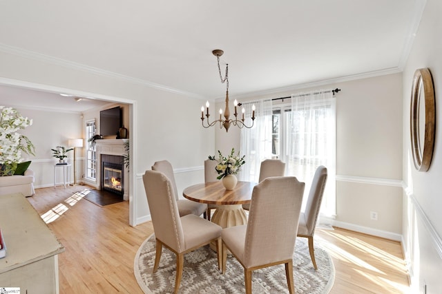 dining area featuring a notable chandelier, crown molding, and light hardwood / wood-style floors