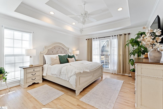 bedroom with multiple windows, ornamental molding, a raised ceiling, and ceiling fan