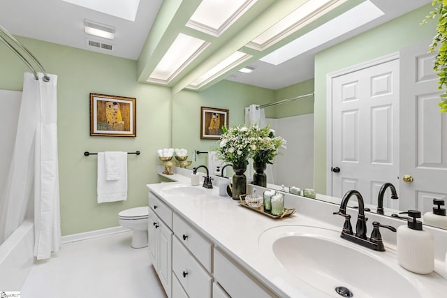 full bathroom with vanity, toilet, shower / bath combo with shower curtain, and a skylight