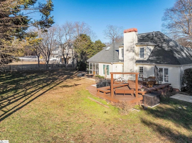 back of house featuring a wooden deck and a lawn