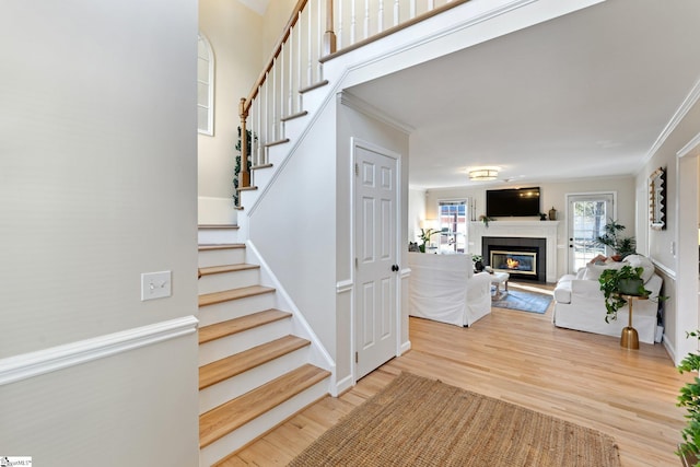 stairway with crown molding and hardwood / wood-style floors