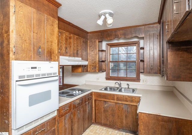 kitchen with electric cooktop, sink, a textured ceiling, and white oven