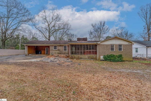 rear view of house with a carport and a sunroom