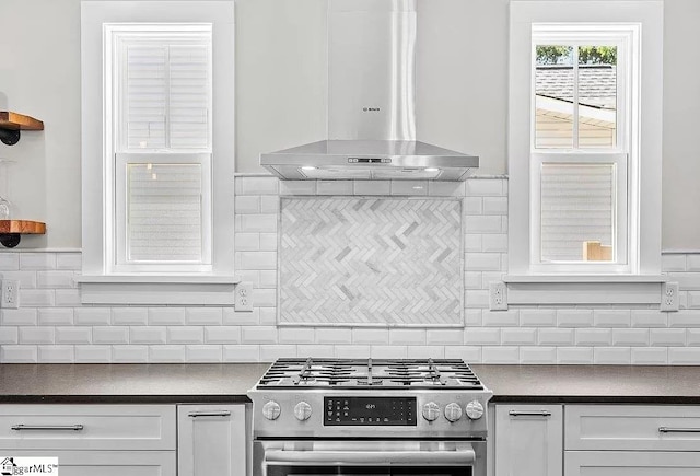 kitchen with white cabinetry, wall chimney exhaust hood, gas stove, and decorative backsplash