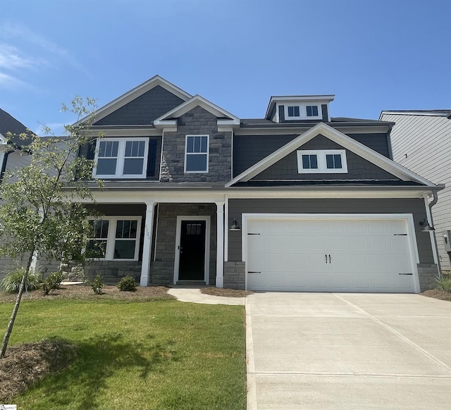 craftsman-style home featuring a garage and a front yard