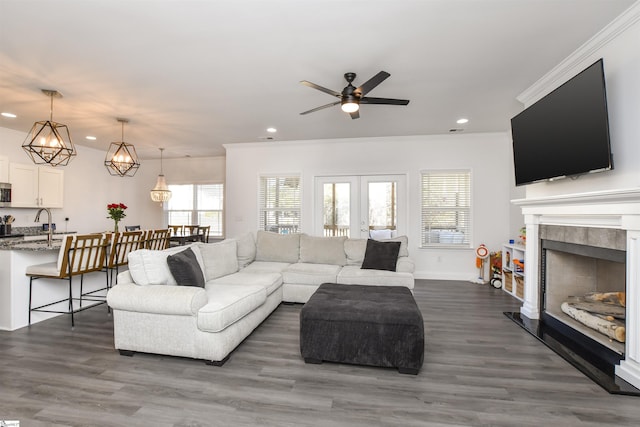 living room featuring crown molding, dark hardwood / wood-style flooring, and a tiled fireplace