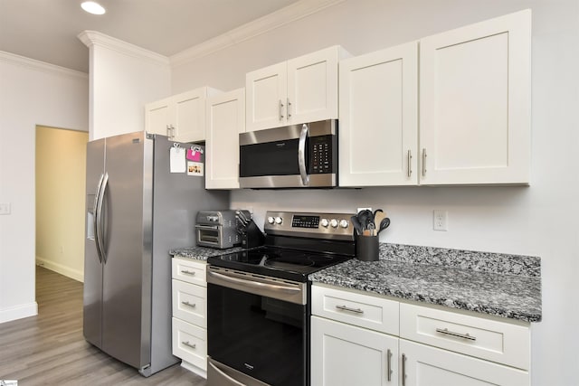 kitchen with white cabinetry, appliances with stainless steel finishes, and ornamental molding