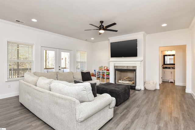 living room with ornamental molding, plenty of natural light, and french doors