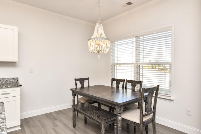 dining space featuring an inviting chandelier, crown molding, and wood-type flooring