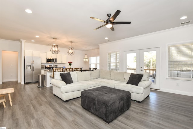 living room with ornamental molding, hardwood / wood-style floors, ceiling fan, and french doors