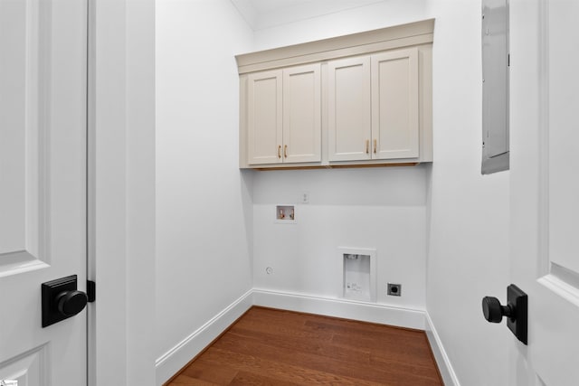 clothes washing area featuring hardwood / wood-style flooring, cabinets, hookup for an electric dryer, and hookup for a washing machine