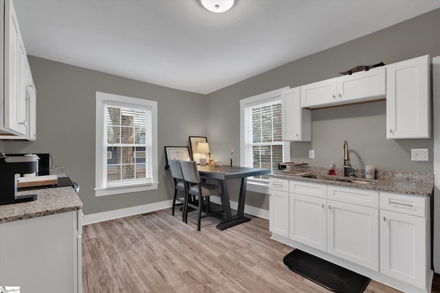 kitchen featuring white cabinetry, sink, and a healthy amount of sunlight