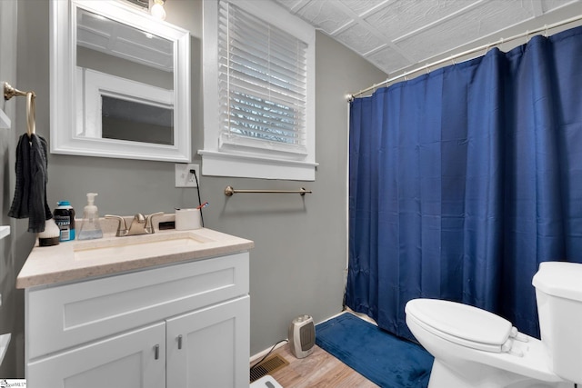 bathroom featuring a shower with curtain, wood-type flooring, toilet, and vanity