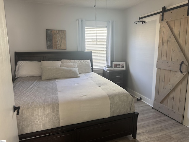 bedroom featuring light hardwood / wood-style flooring and a barn door