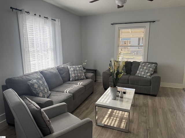 living room with ceiling fan, dark hardwood / wood-style flooring, and a textured ceiling