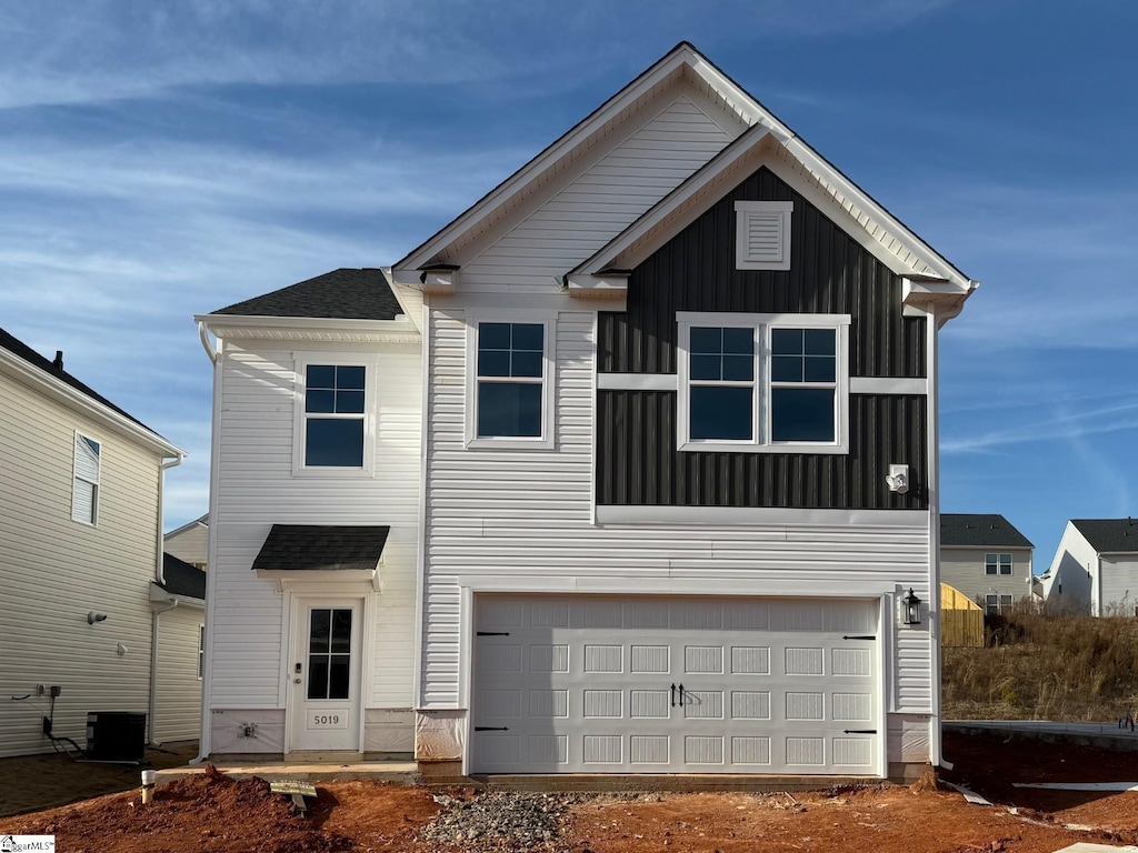 view of front of home with a garage and central air condition unit