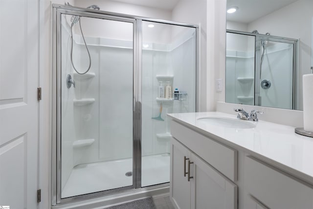 bathroom with a shower with door and vanity