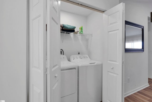 washroom with separate washer and dryer and light hardwood / wood-style flooring