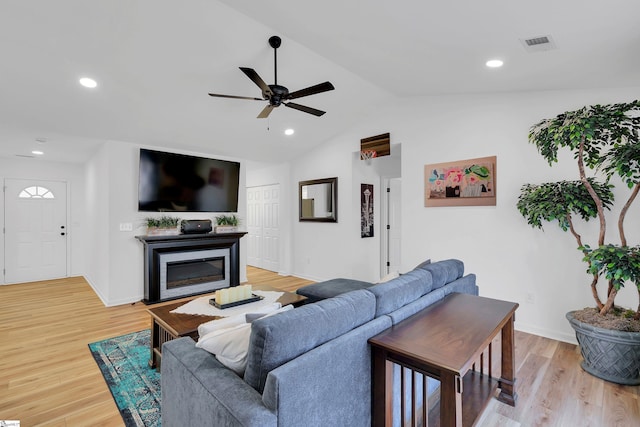 living room with lofted ceiling, light hardwood / wood-style flooring, and ceiling fan