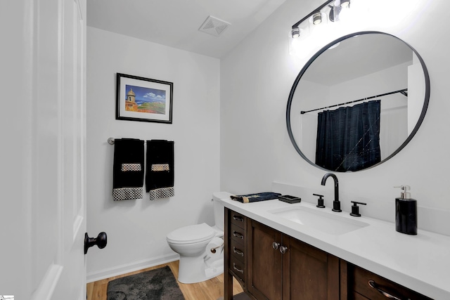 bathroom featuring hardwood / wood-style flooring, vanity, a shower with shower curtain, and toilet