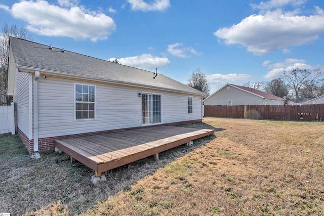 rear view of house featuring a yard and a deck