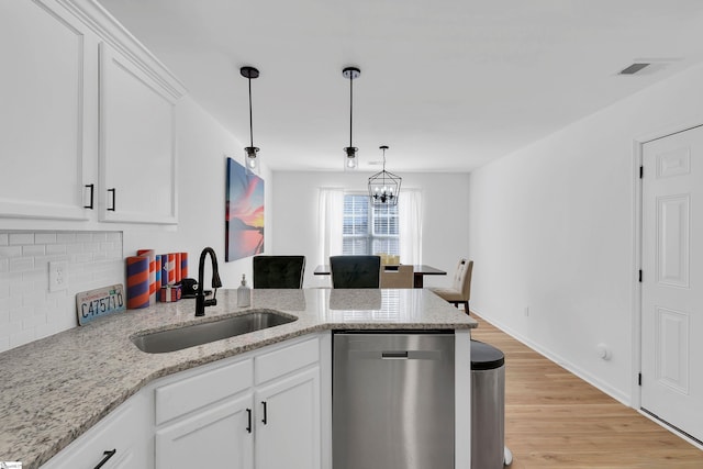 kitchen with sink, light hardwood / wood-style flooring, dishwasher, light stone countertops, and white cabinets