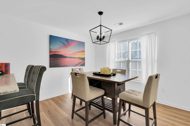 dining room featuring an inviting chandelier and light hardwood / wood-style floors