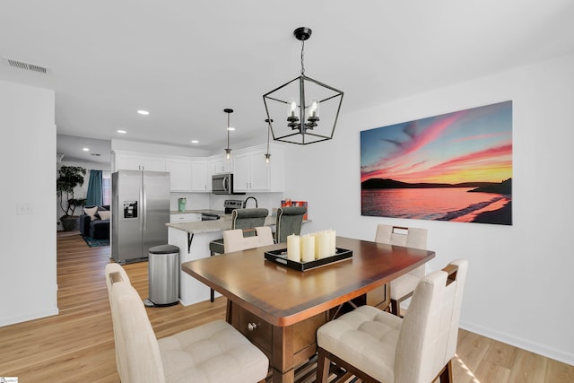 dining room with a notable chandelier and light hardwood / wood-style flooring