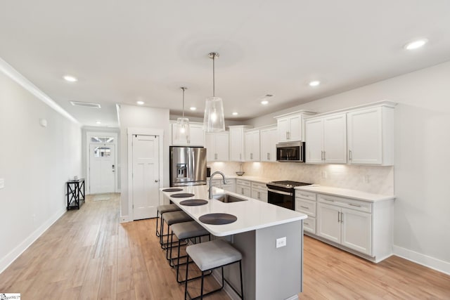 kitchen with white cabinetry, sink, backsplash, and stainless steel appliances