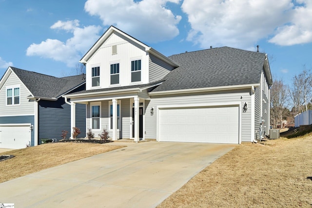 view of front of home featuring cooling unit, a garage, a front lawn, and covered porch