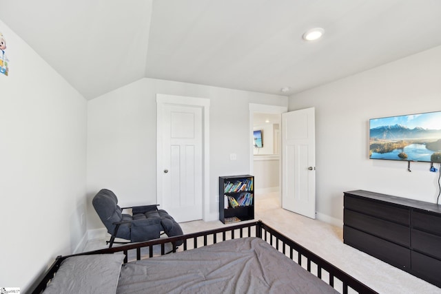 bedroom with vaulted ceiling and light colored carpet