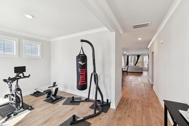 workout area with crown molding and hardwood / wood-style flooring