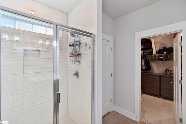 bathroom with an enclosed shower and hardwood / wood-style floors