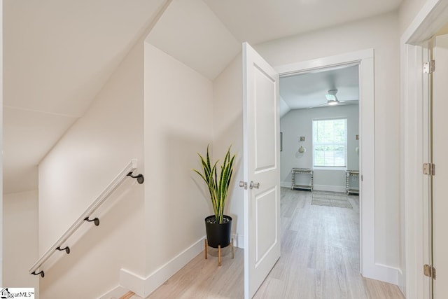 corridor with vaulted ceiling and light hardwood / wood-style flooring