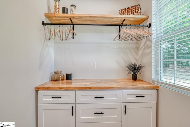 bar with white cabinets and wood counters