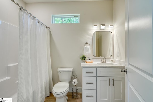 bathroom with hardwood / wood-style flooring, vanity, a shower with curtain, and toilet