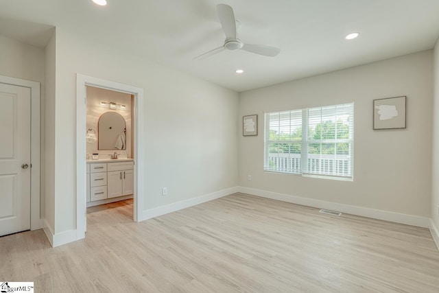 unfurnished bedroom with ceiling fan, ensuite bath, and light hardwood / wood-style floors