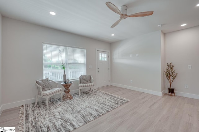 living area featuring ceiling fan and light hardwood / wood-style flooring