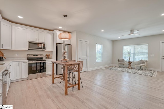 kitchen featuring white cabinetry, pendant lighting, and stainless steel appliances