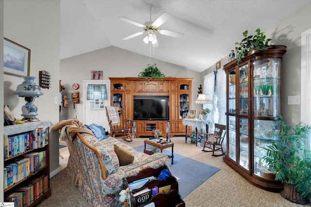 living room featuring ceiling fan, carpet floors, and vaulted ceiling