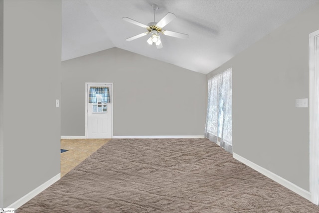 interior space with vaulted ceiling, a textured ceiling, and ceiling fan