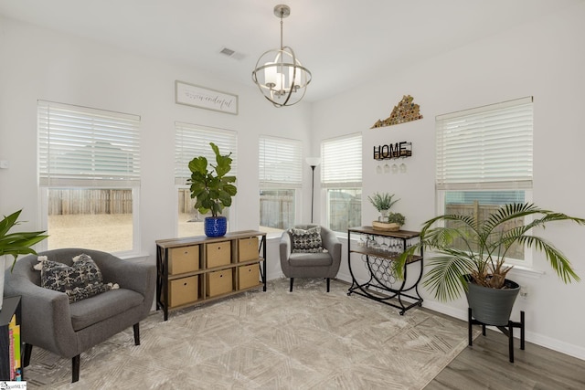 living area with light hardwood / wood-style flooring and a chandelier