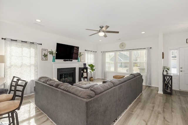 living room with ceiling fan, a healthy amount of sunlight, and light hardwood / wood-style floors