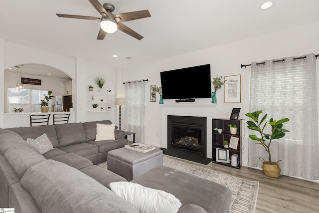 living room featuring wood-type flooring and ceiling fan