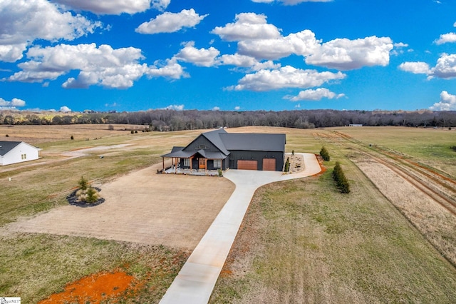 view of front of property with a rural view, a garage, and a front yard