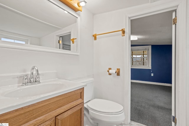 bathroom featuring vanity, a healthy amount of sunlight, and toilet